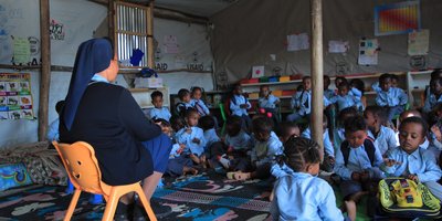 A Sister teaching children in a temporary classroom, ensuring education continues even in challenging circumstances